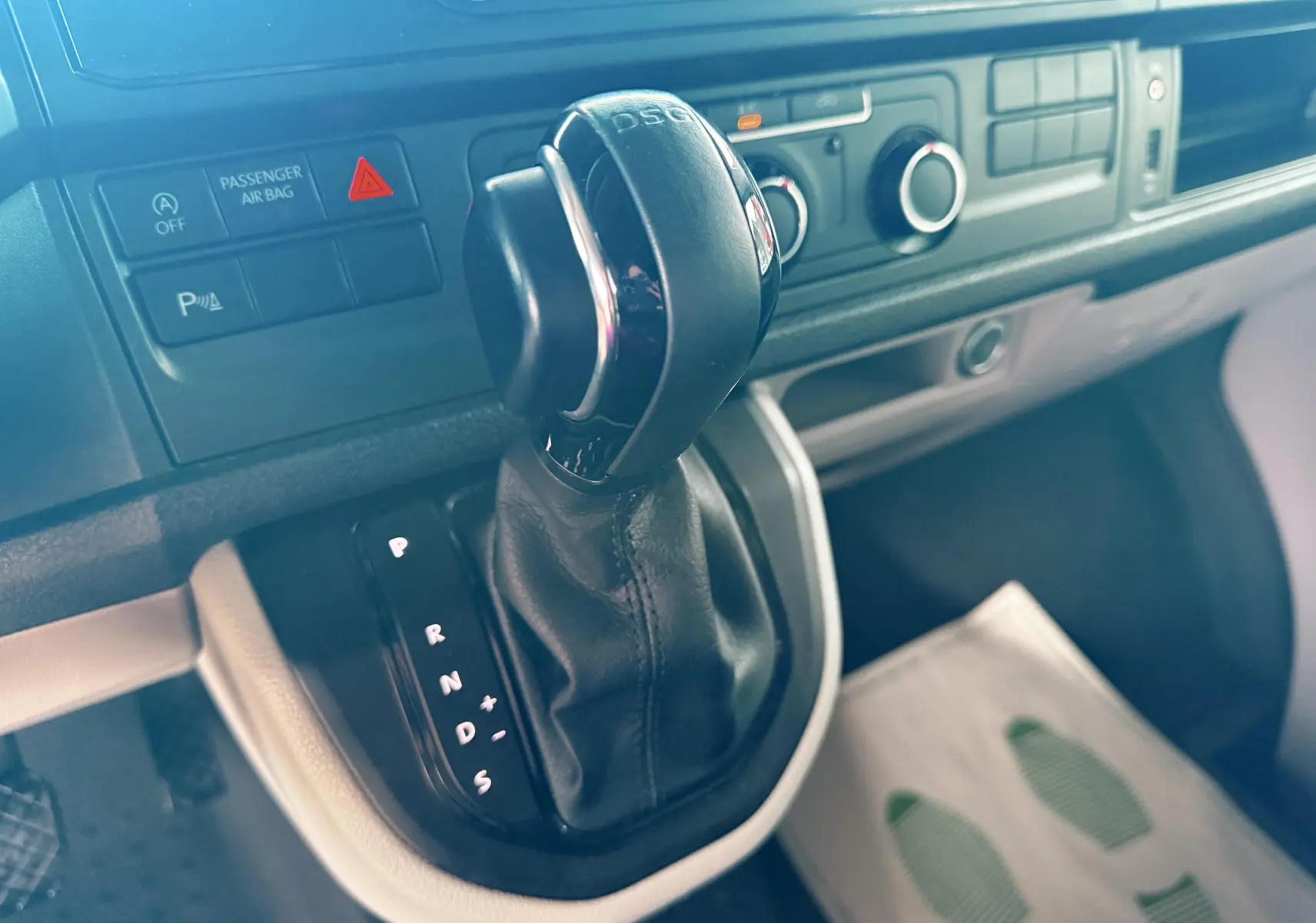 Gros plan sur la commande de boîte automatique DSG du Volkswagen Transporter L1H1 blanc, tableau de bord en arrière-plan.