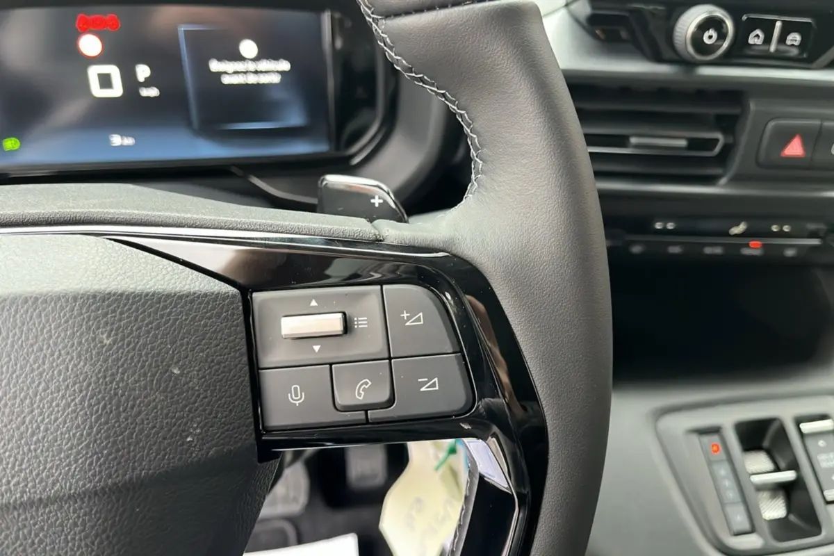 Gros plan sur le volant cuir multifonctions du Citroën Berlingo 2026, avec commandes audio et palettes au volant.
