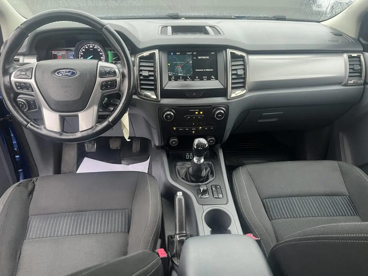Intérieur avant du Ford Ranger bleu 2019, tableau de bord avec écran tactile et volant cuir multifonctions.