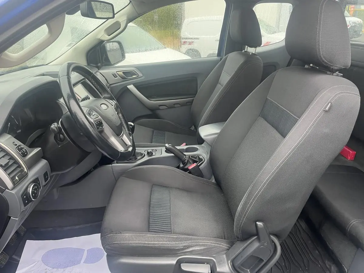 Intérieur avant du Ford Ranger bleu 2019, vue côté conducteur montrant sièges tissu gris et volant multifonction.