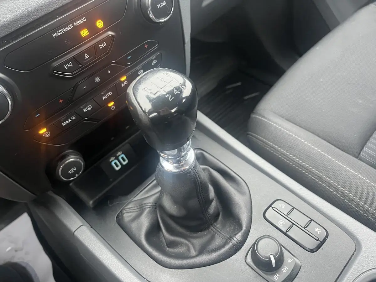 Le levier de vitesses manuel noir du Ford Ranger 2.2 TDCi 2019, avec console centrale et commandes visibles.