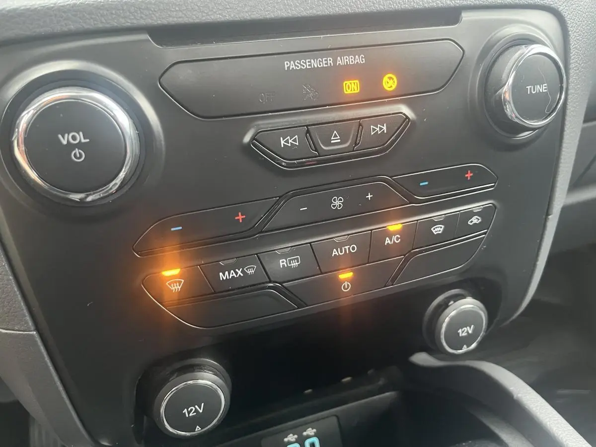 Détail du tableau de bord noir du Ford Ranger 2019, avec commandes climatisation et boutons lumineux allumés.