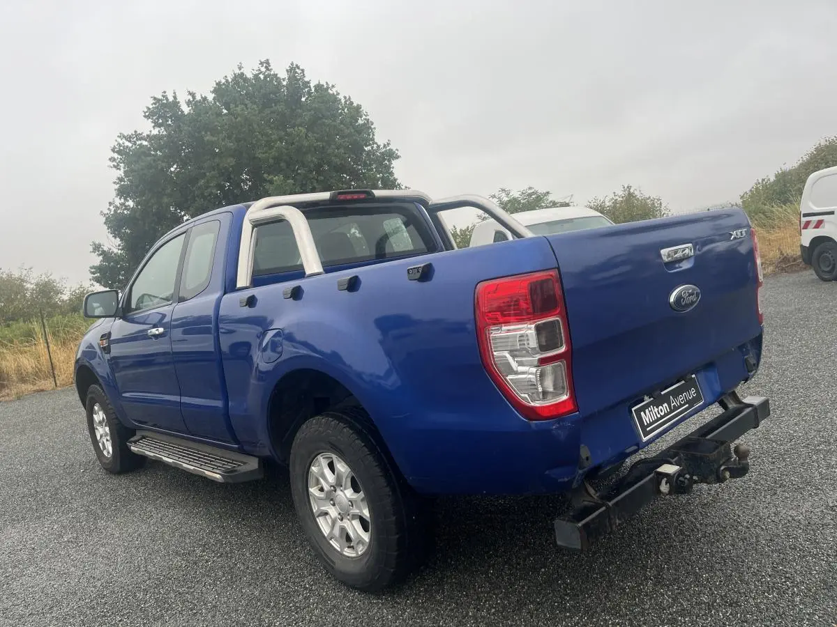 Ford Ranger 2.2 TDCi bleu en 3/4 arrière droit avec crochet d'attelage et barres de protection chromées