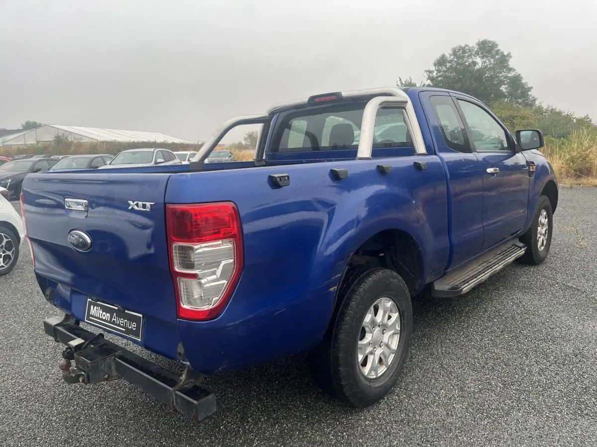 Ford Ranger XLT bleu en 3/4 arrière droit avec crochet d'attelage et barres de protection sur plateau