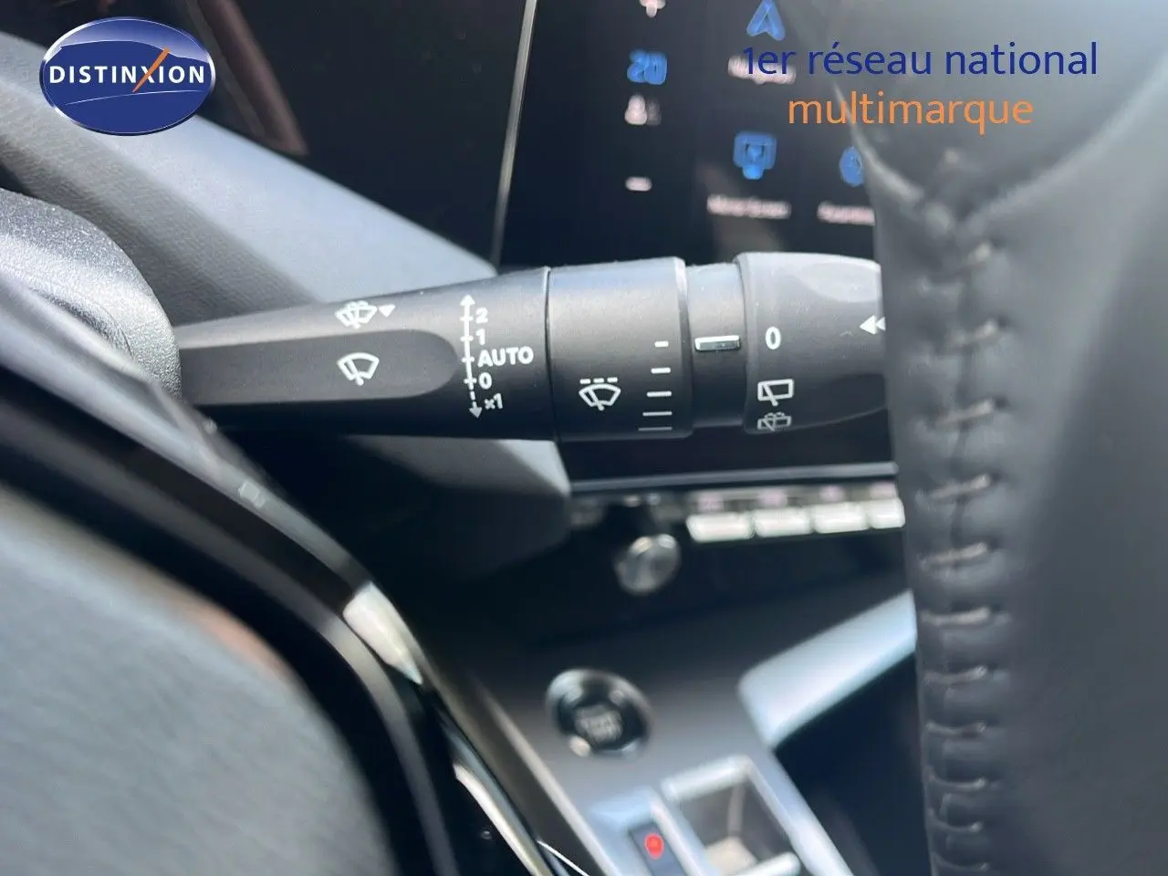 Gros plan sur la commande d'essuie-glace à gauche du volant dans l'habitacle d'une Peugeot 308 1.2 Hybrid 2024.