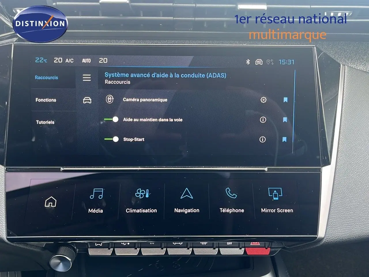 Écran tactile central du tableau de bord de la Peugeot 308 hybride 2024 affichant les aides à la conduite et la climatisation.