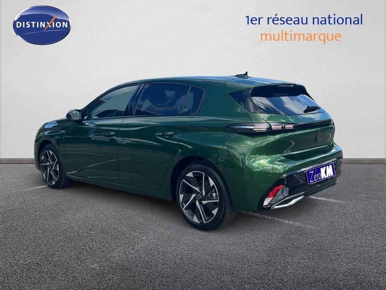 Peugeot 308 vert olivine métal vue 3/4 arrière côté gauche, avec jantes alliage et feux arrière LED distinctifs.