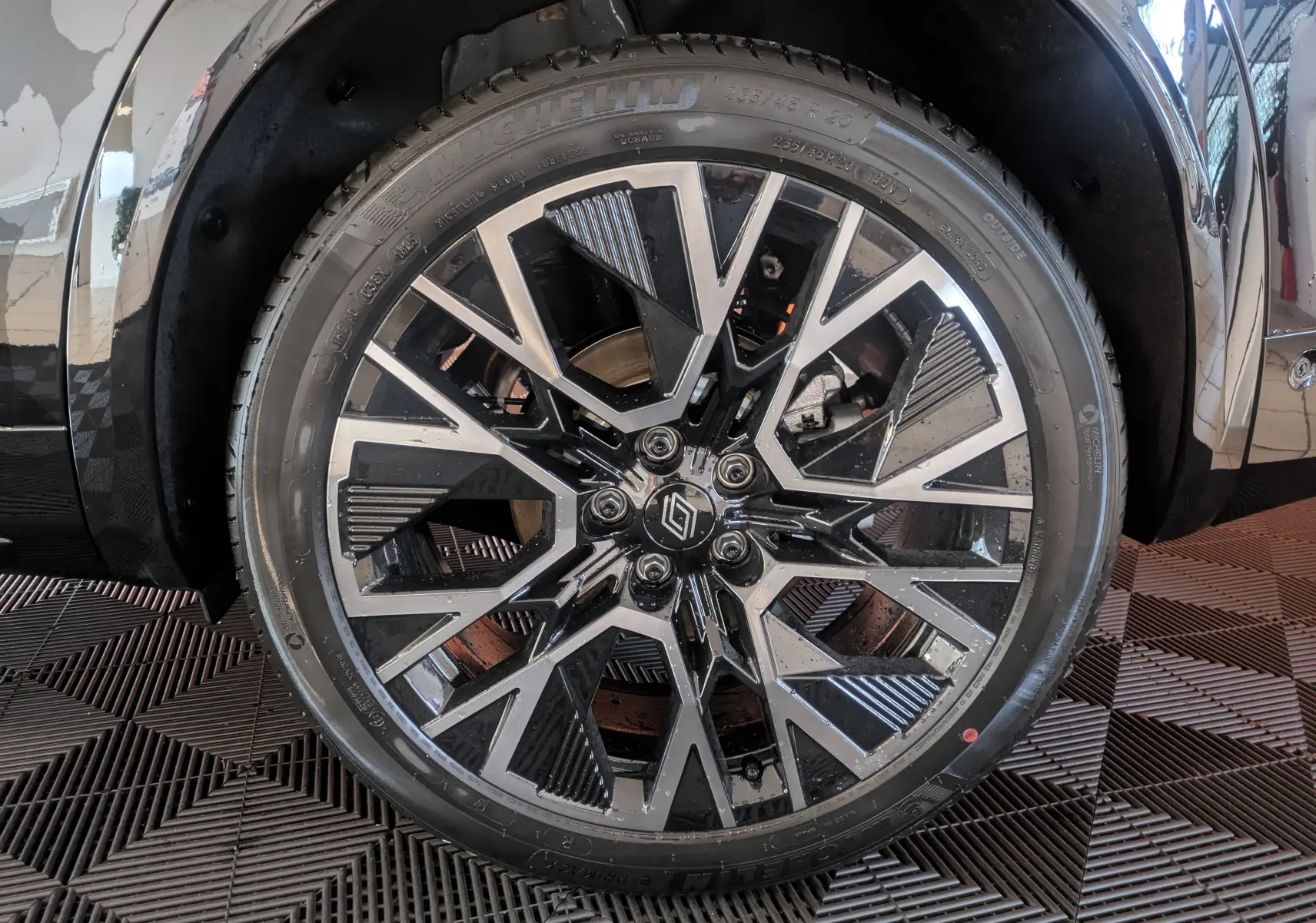 Vue rapprochée sur la roue arrière droite d'un Renault Austral noir, avec jante alliage 20 pouces et carrosserie brillante.