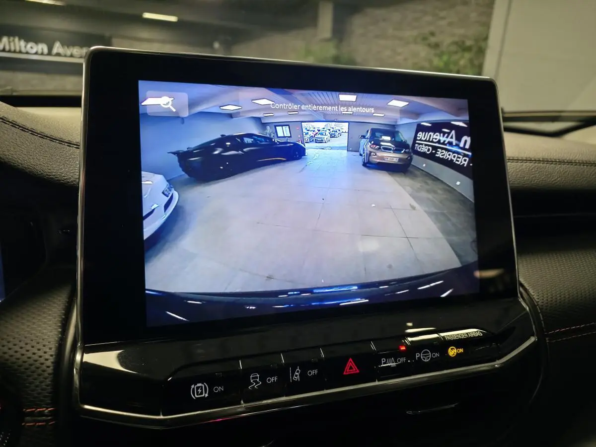 Vue de l'écran de caméra de recul affichant l'arrière du Jeep Compass Trailhawk noir en intérieur.