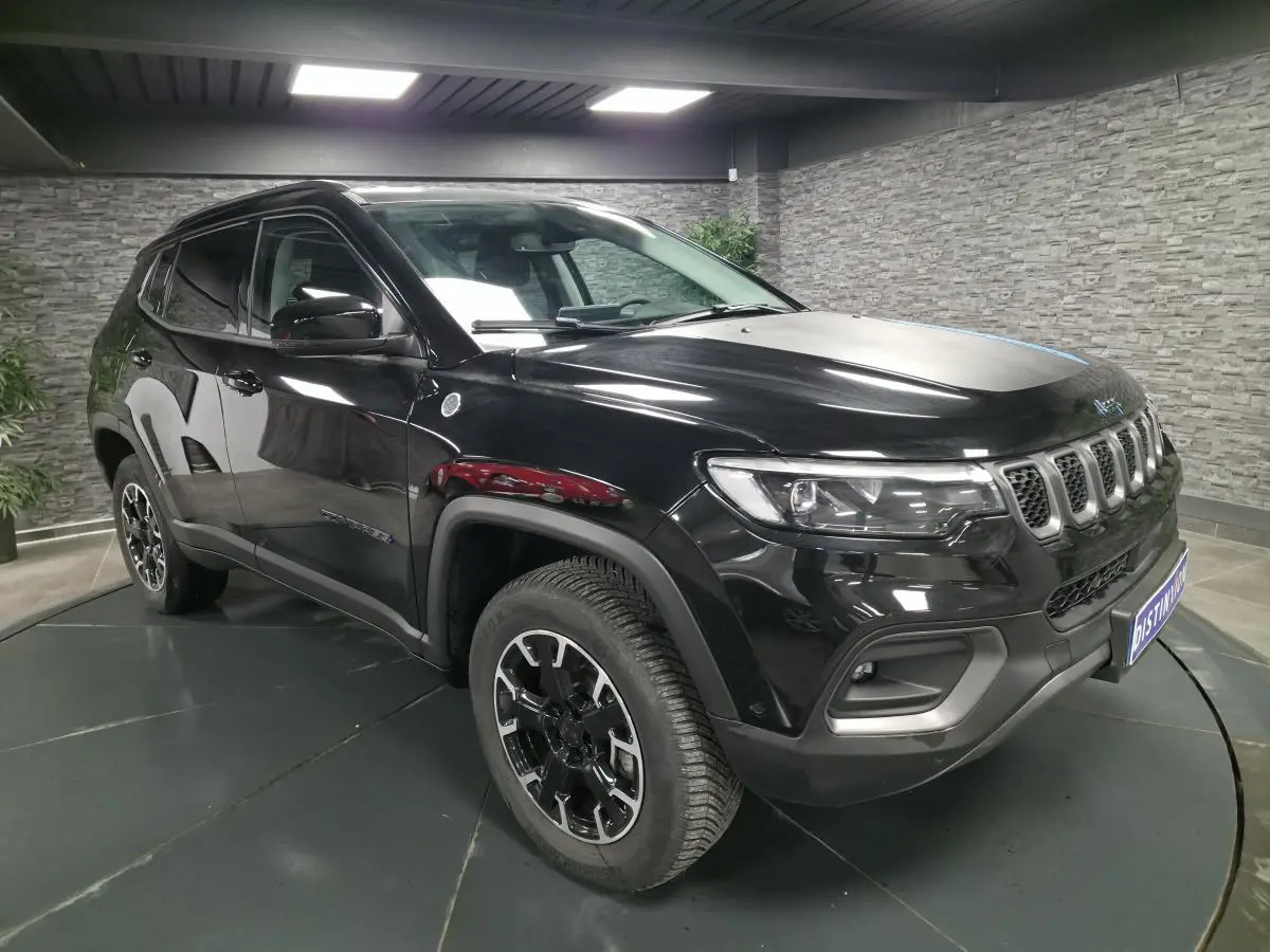 Jeep Compass Trailhawk noir en 3/4 avant droit avec jantes alliage et signature lumineuse LED visible.