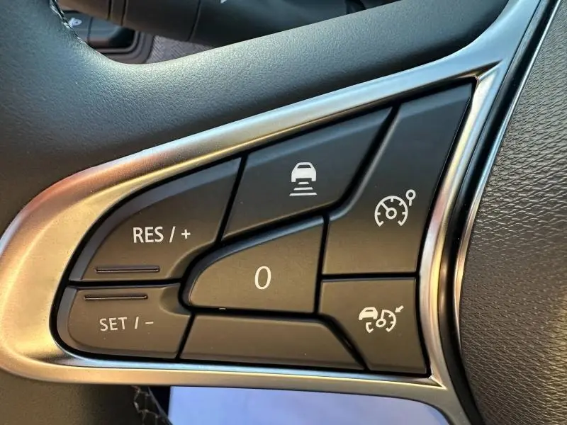 Gros plan sur les commandes de régulateur de vitesse au volant d’une Renault Clio 1.6 E-Tech rouge Flamme 2025.