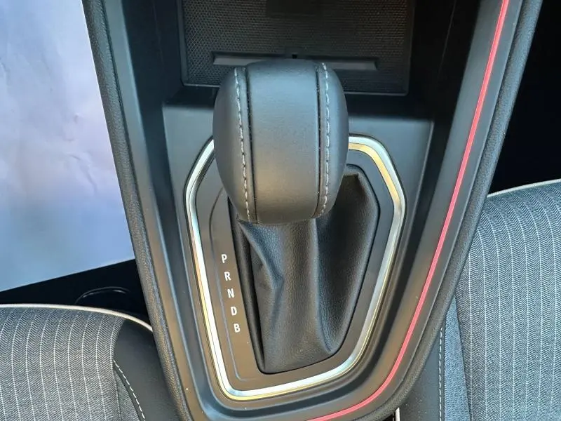 Le levier de vitesse automatique en cuir noir de la Renault Clio 1.6 E-Tech, entouré d’un cadre argenté et d’un insert rouge Flamme.