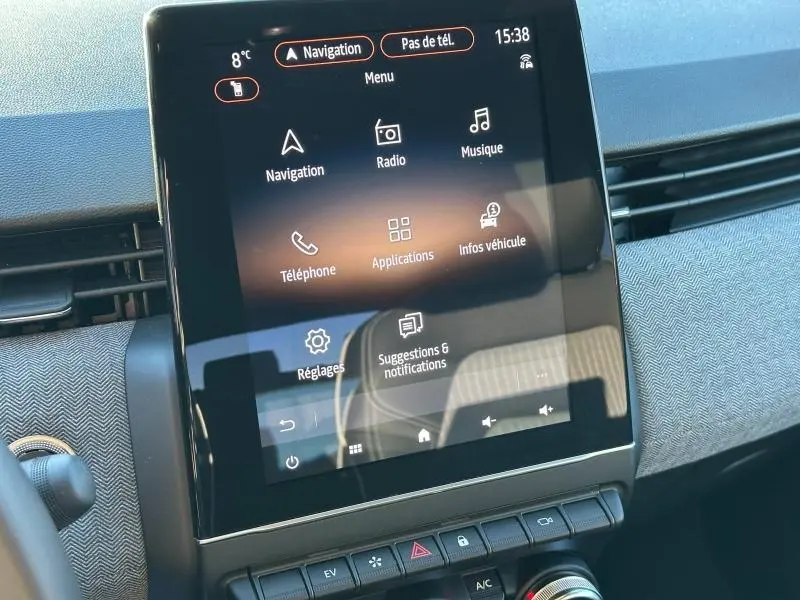 Écran tactile central de la Renault Clio 1.6 E-Tech rouge Flamme, affichant le menu principal avec navigation et applications.