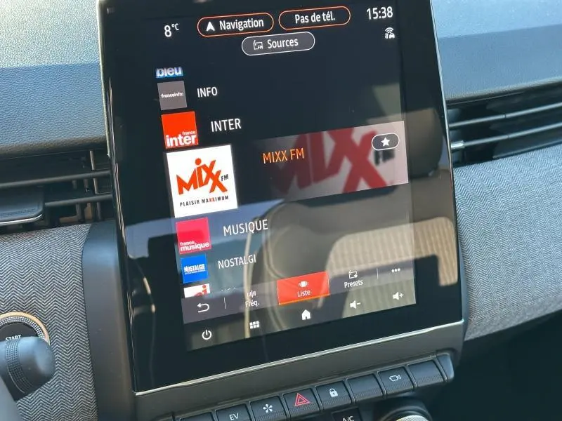 Écran tactile central de la Renault Clio 1.6 E-Tech 145ch full hybrid Techno 2025 affichant les stations radio, intérieur gris.