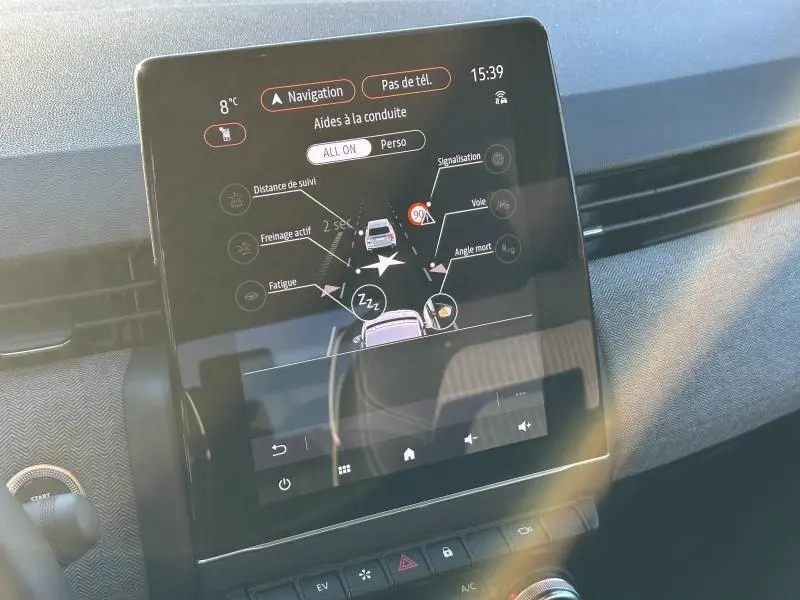 Écran tactile central de la Renault Clio 2025 affichant les aides à la conduite dans un intérieur moderne.