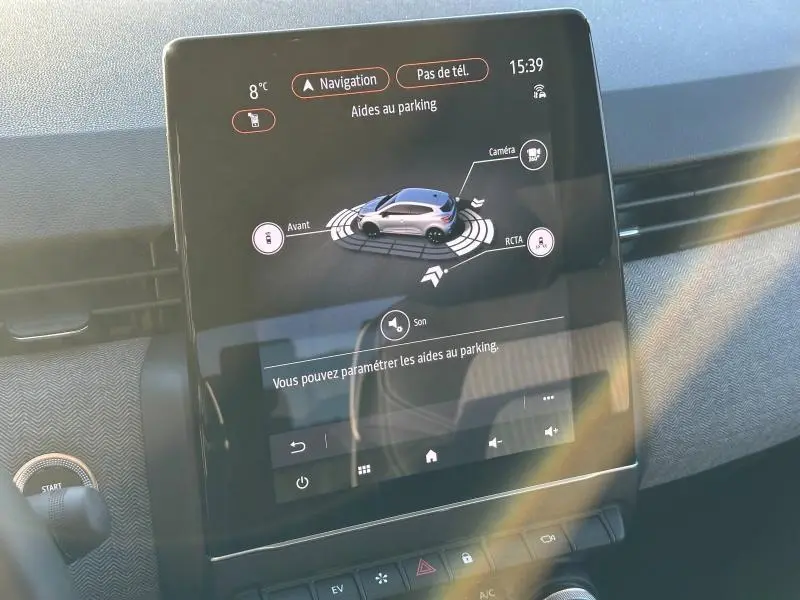 Écran tactile intérieur de la Renault Clio 2025 affichant les aides au parking avec vue 3D du véhicule en gris.