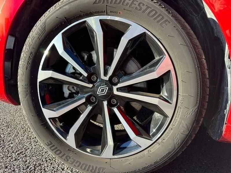 Gros plan sur la jante alliage noire et argentée de la Renault Clio 1.6 E-Tech Rouge Flamme, avec pneu Bridgestone visible.