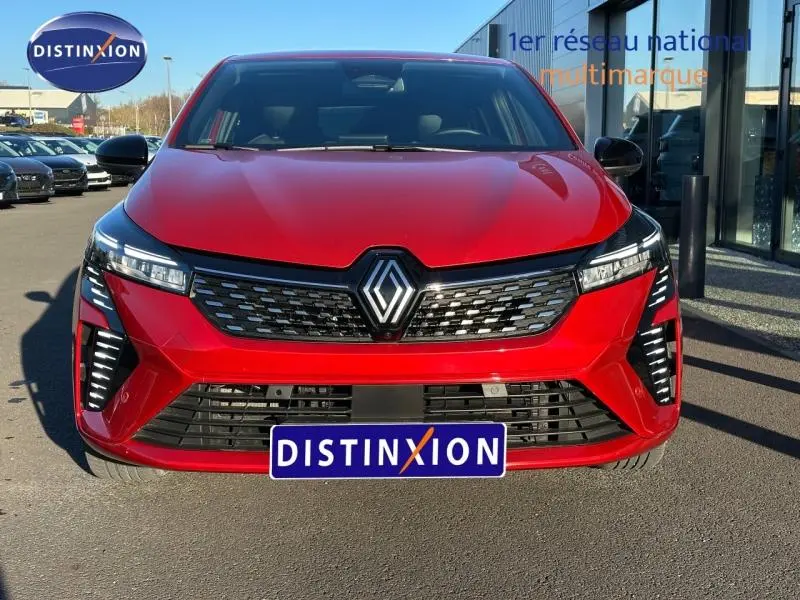 Vue frontale d'une Renault Clio 1.6 E-Tech 145ch rouge flamme avec calandre noire et feux LED distinctifs.