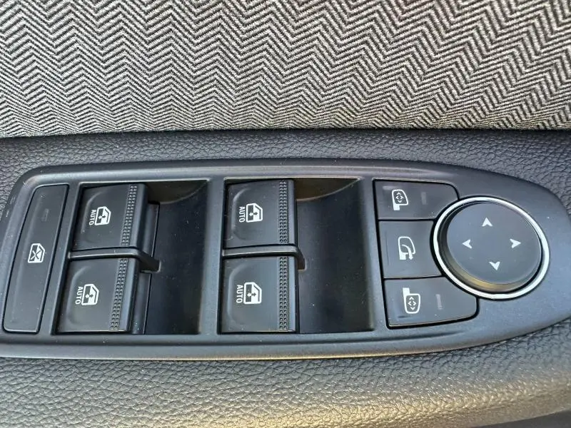 Panneau de commandes des vitres électriques et rétroviseurs sur la portière intérieure d'une Renault Clio 2025.