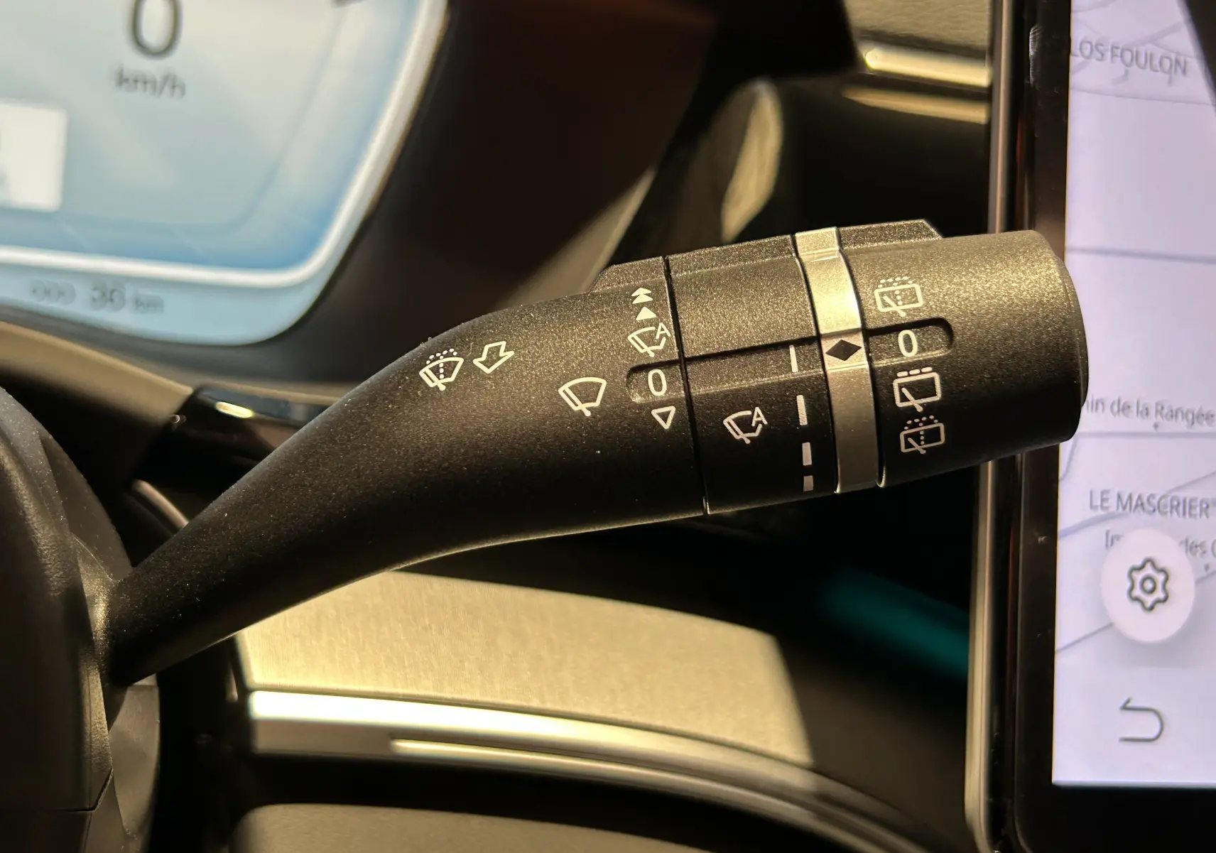 Gros plan sur la manette de commande des essuie-glaces dans l’habitacle du BYD SEAL U, avec tableau de bord et écran tactile visibles.