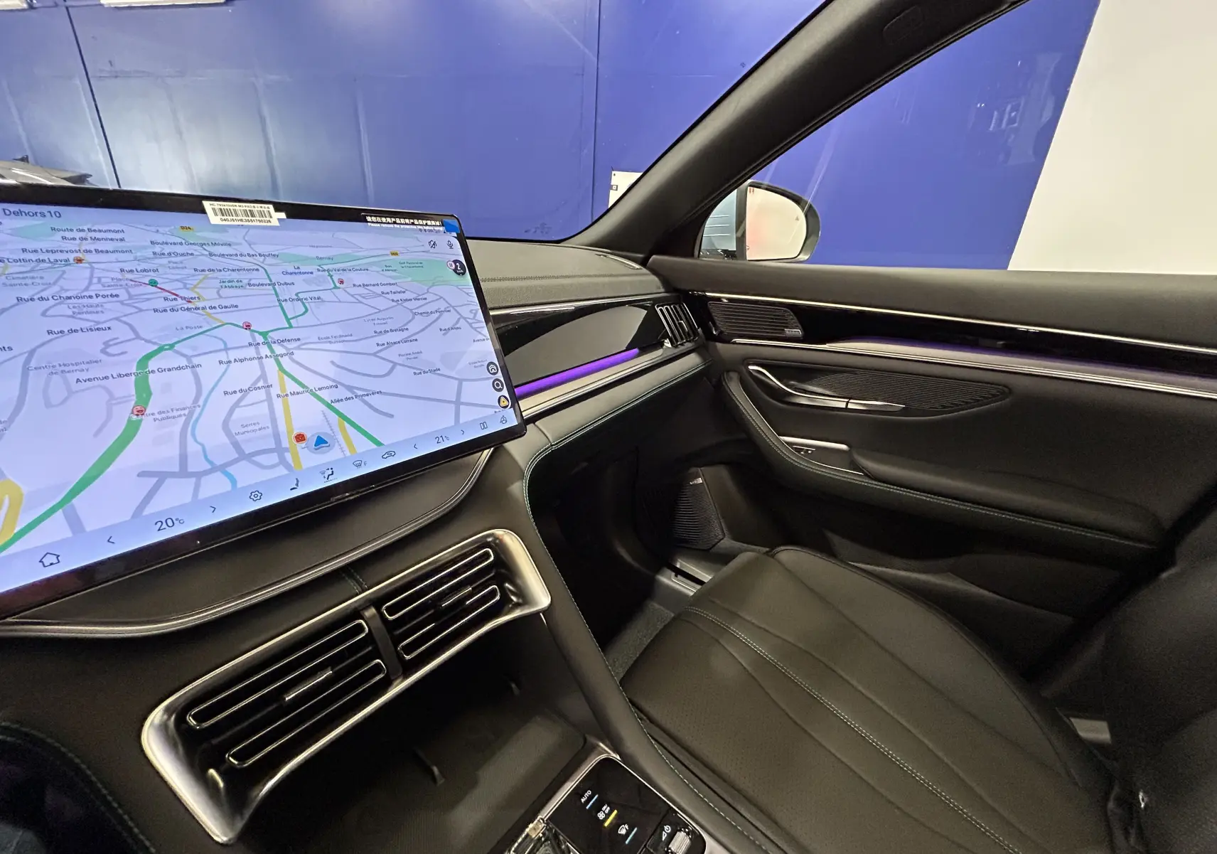 Intérieur avant droit du BYD SEAL U 2025 avec écran tactile GPS, sellerie cuir noire et éclairage d'ambiance violet.