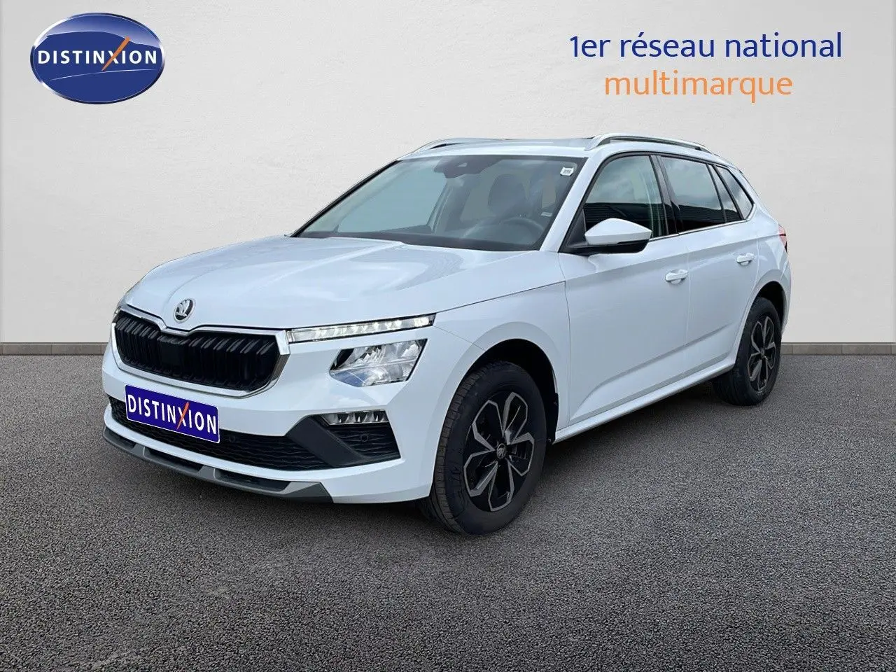 Vue 3/4 avant d’un Skoda Kamiq blanc glacier avec calandre noire et jantes alliage foncé, sur fond neutre extérieur.