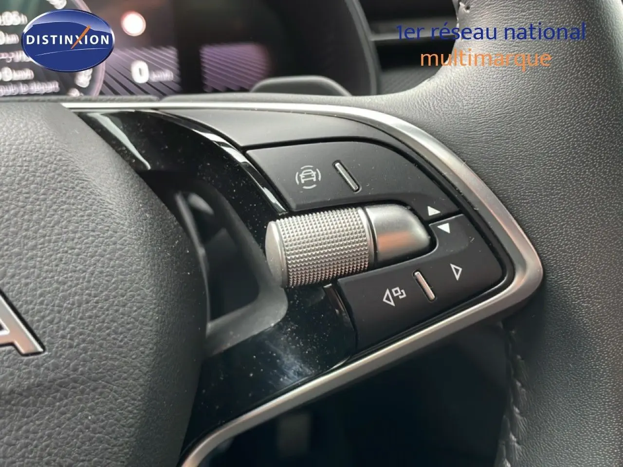 Gros plan sur les commandes multifonctions du volant du Skoda Kamiq blanc glacier, avec molette et boutons noirs.