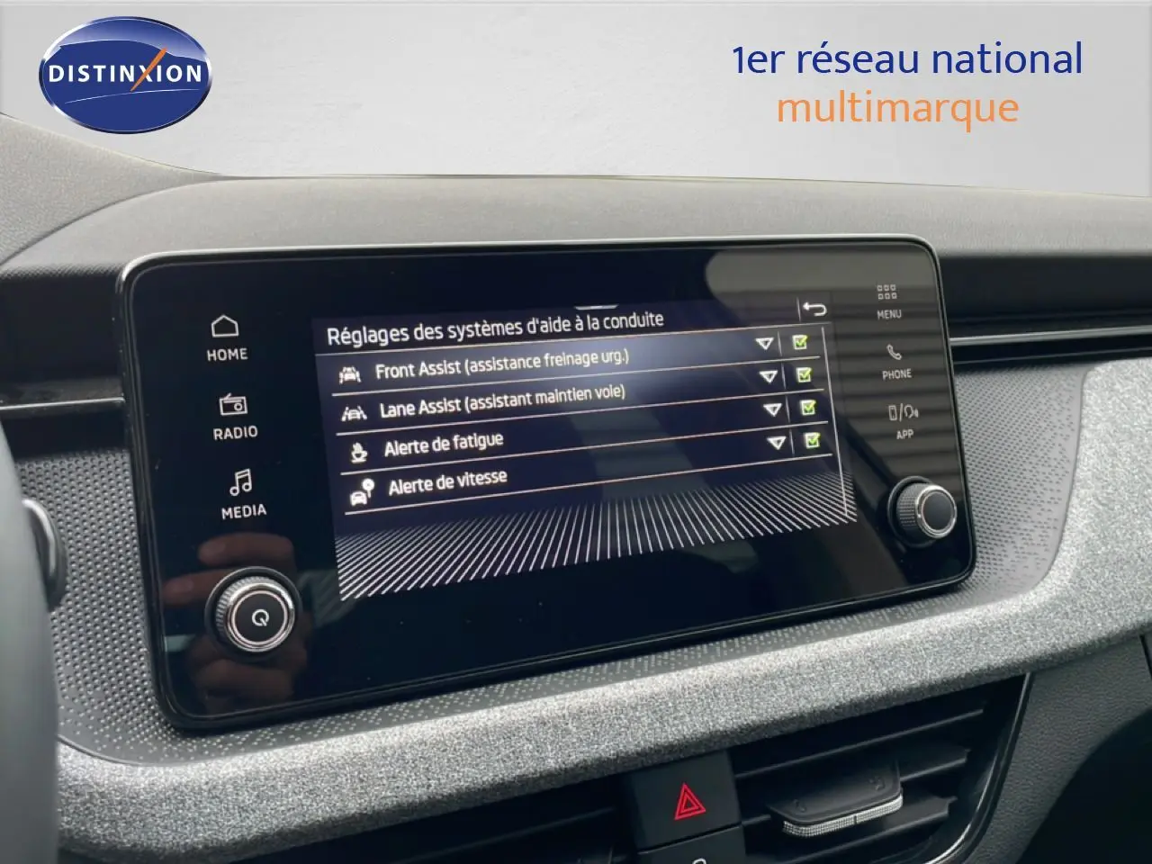 Écran tactile central du Skoda Kamiq 2025 montrant les réglages d’aide à la conduite dans un intérieur noir.