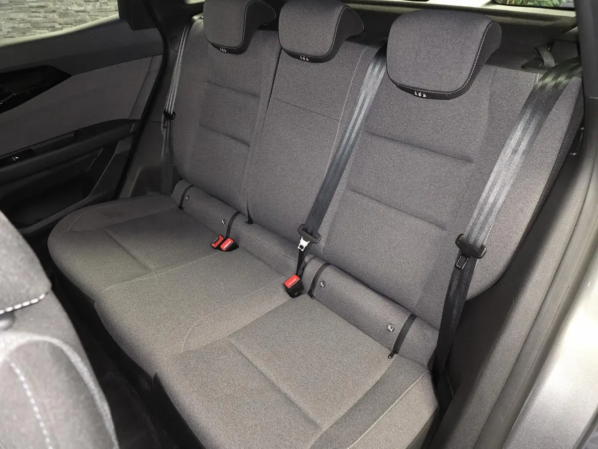 Vue intérieure de la banquette arrière en tissu gris foncé du Renault Austral 2024, avec ceintures de sécurité visibles.