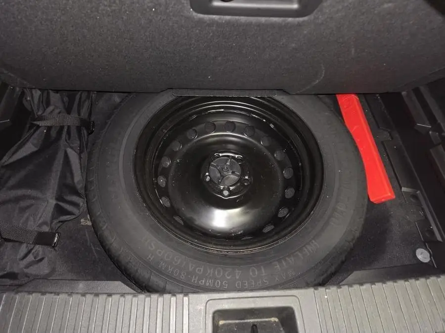 Vue rapprochée de la roue de secours galette noire dans le coffre du Renault Austral 2024 gris.