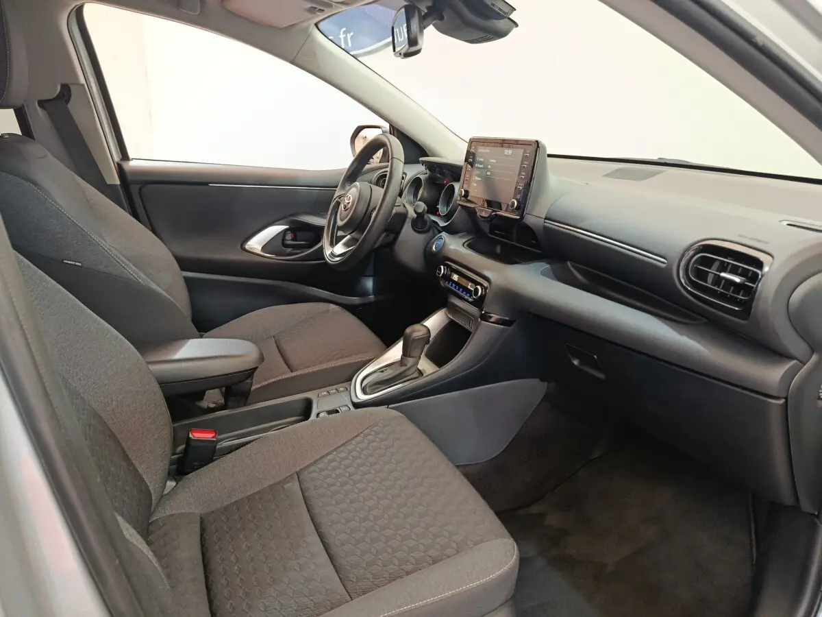 Intérieur avant droit de la Toyota Yaris Hybride 116h 2023 avec sièges gris et écran tactile central.