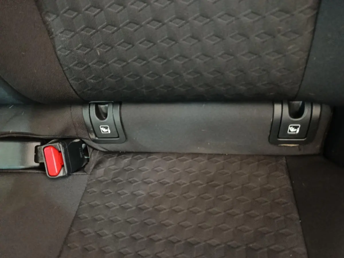 Détail de la banquette arrière noire de la Toyota Yaris hybride 2023, montrant les attaches Isofix et la boucle de ceinture.
