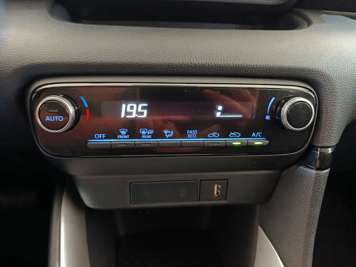 Gros plan sur la commande de climatisation digitale avec affichage à LED dans une Toyota Yaris Hybride 116h gris clair.