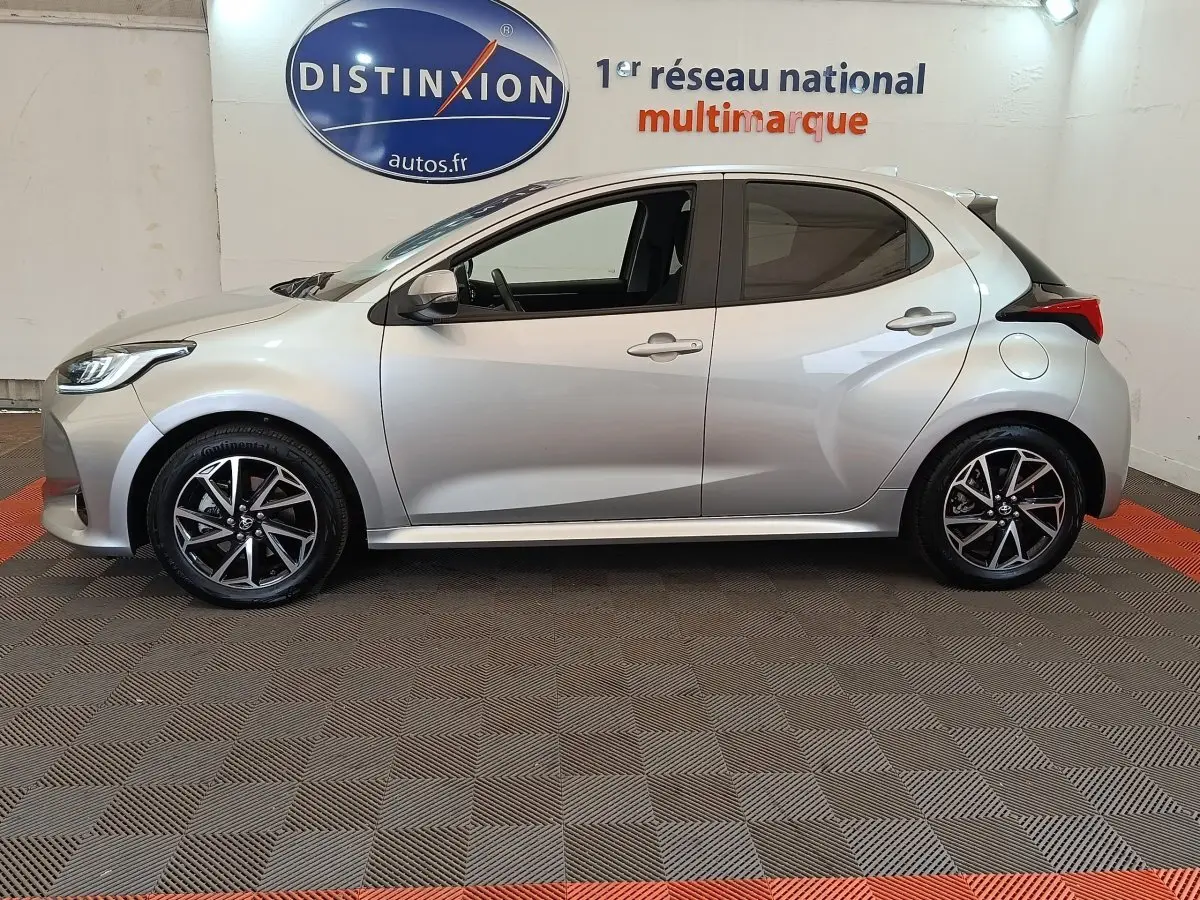 Profil côté gauche de la Toyota Yaris Hybride 116h Design gris clair 2023, avec jantes alliage et feux arrière distinctifs.