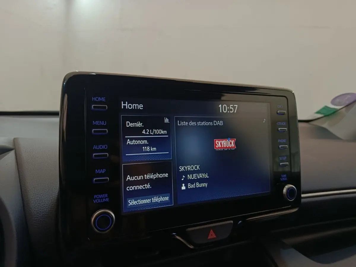 Écran tactile central de la Toyota Yaris hybride 2023 affichant une station radio, vue intérieure rapprochée.