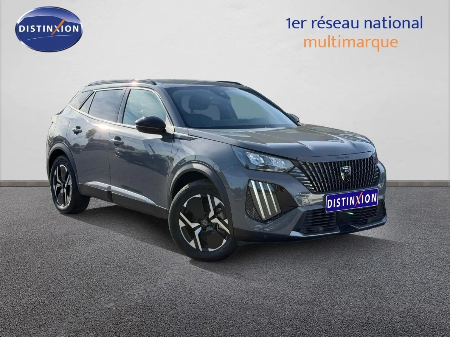 Peugeot e-2008 gris Artense en 3/4 avant droit, SUV électrique avec jantes alu et barres de toit visibles.
