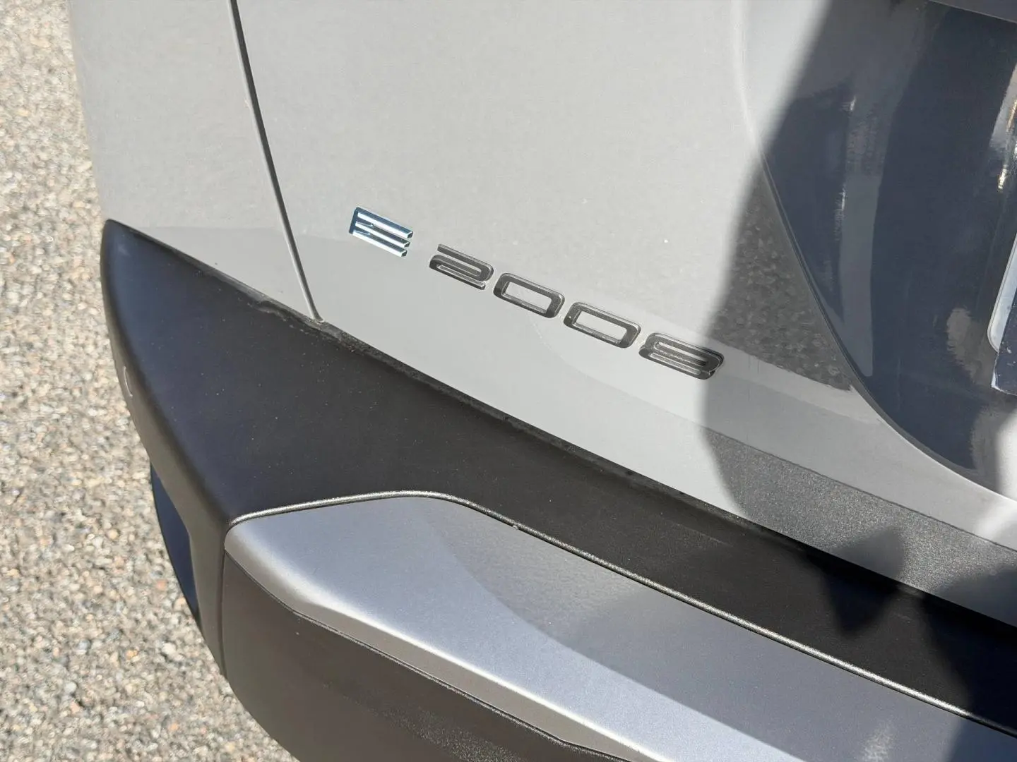 Détail du logo e-2008 sur le hayon arrière côté droit d’un Peugeot 2008 gris Artense.
