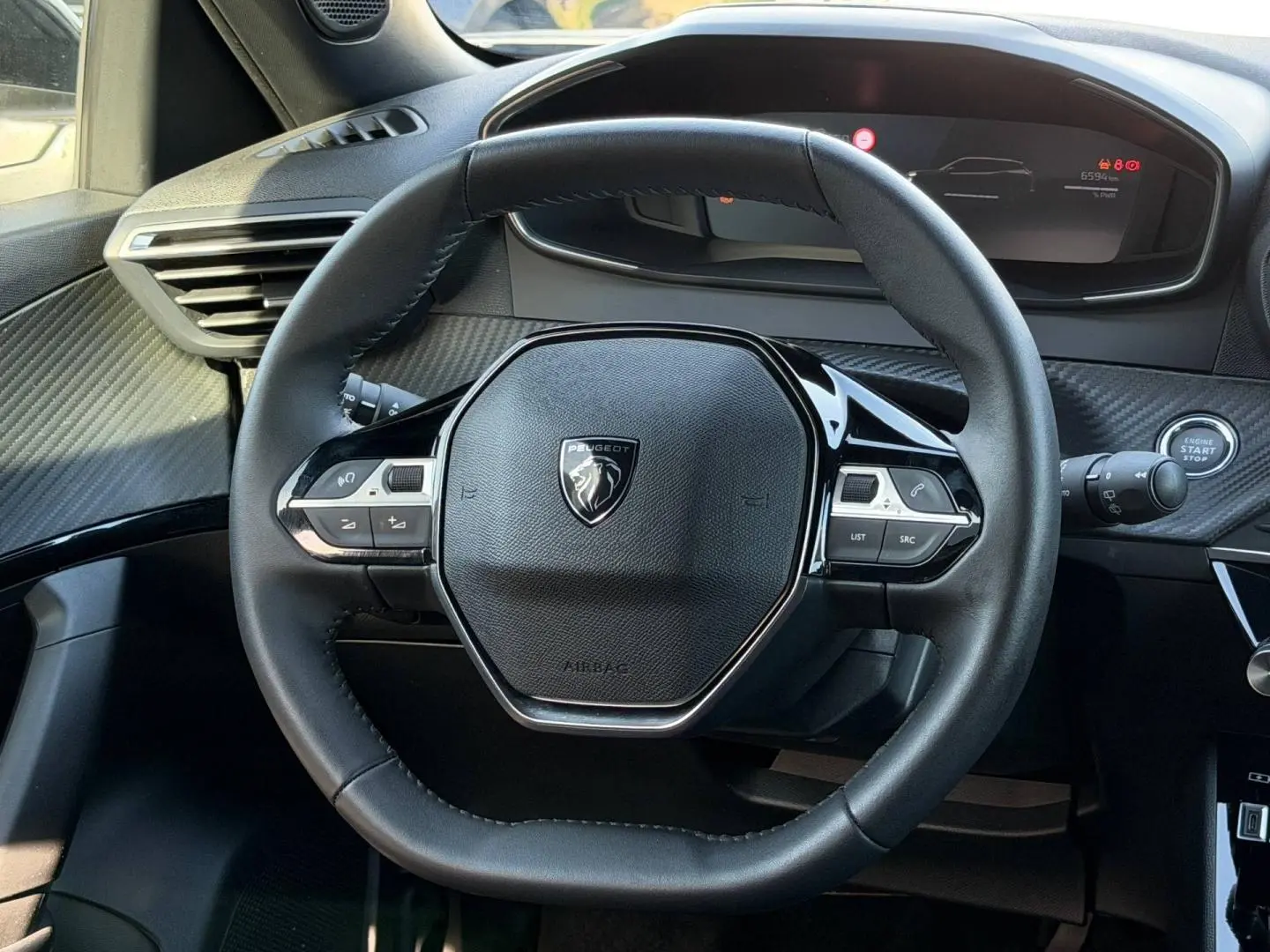 Volant multifonction noir de la Peugeot e-2008 2025, vue de face avec tableau de bord numérique en arrière-plan.