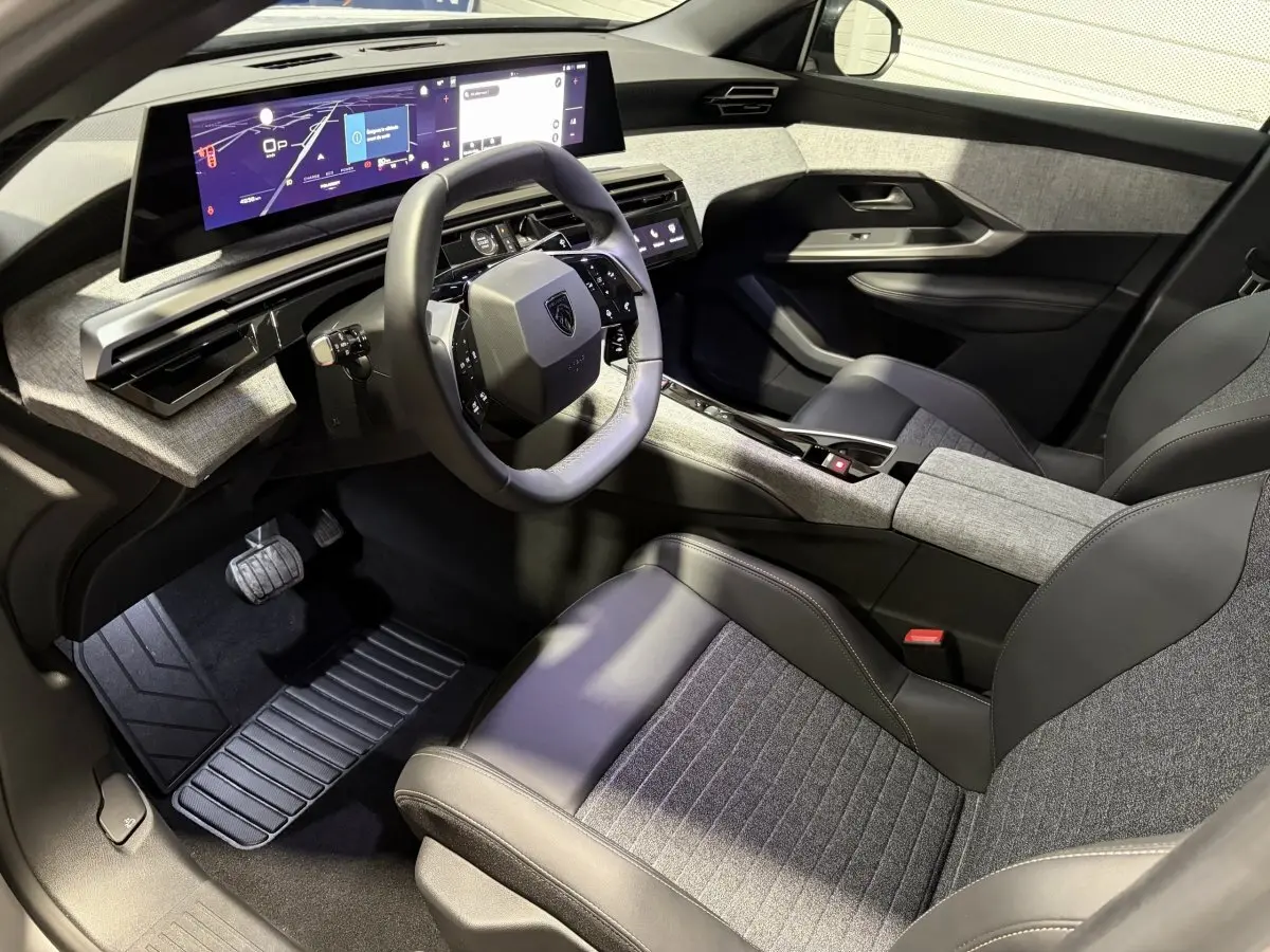 Intérieur Peugeot 3008 hybride 2026 vu côté conducteur, volant compact et grand écran tactile panoramique.