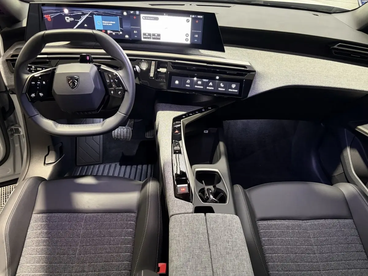 Vue intérieure avant du Peugeot 3008 blanc 2026, mettant en valeur le tableau de bord numérique et la console centrale design.