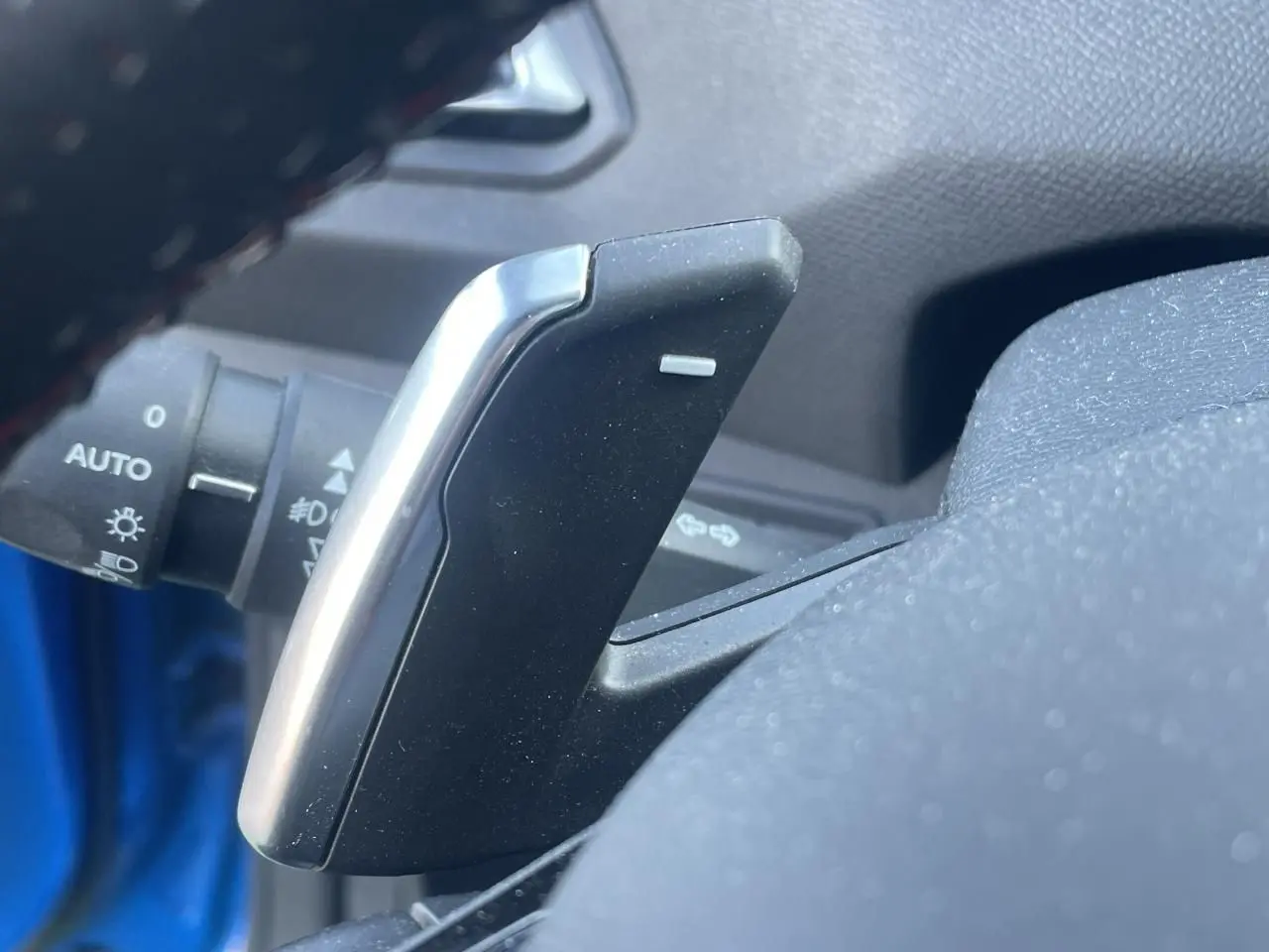 Gros plan sur la palette de changement de vitesse côté droit du volant d'une Peugeot 308 SW bleu Vertigo.