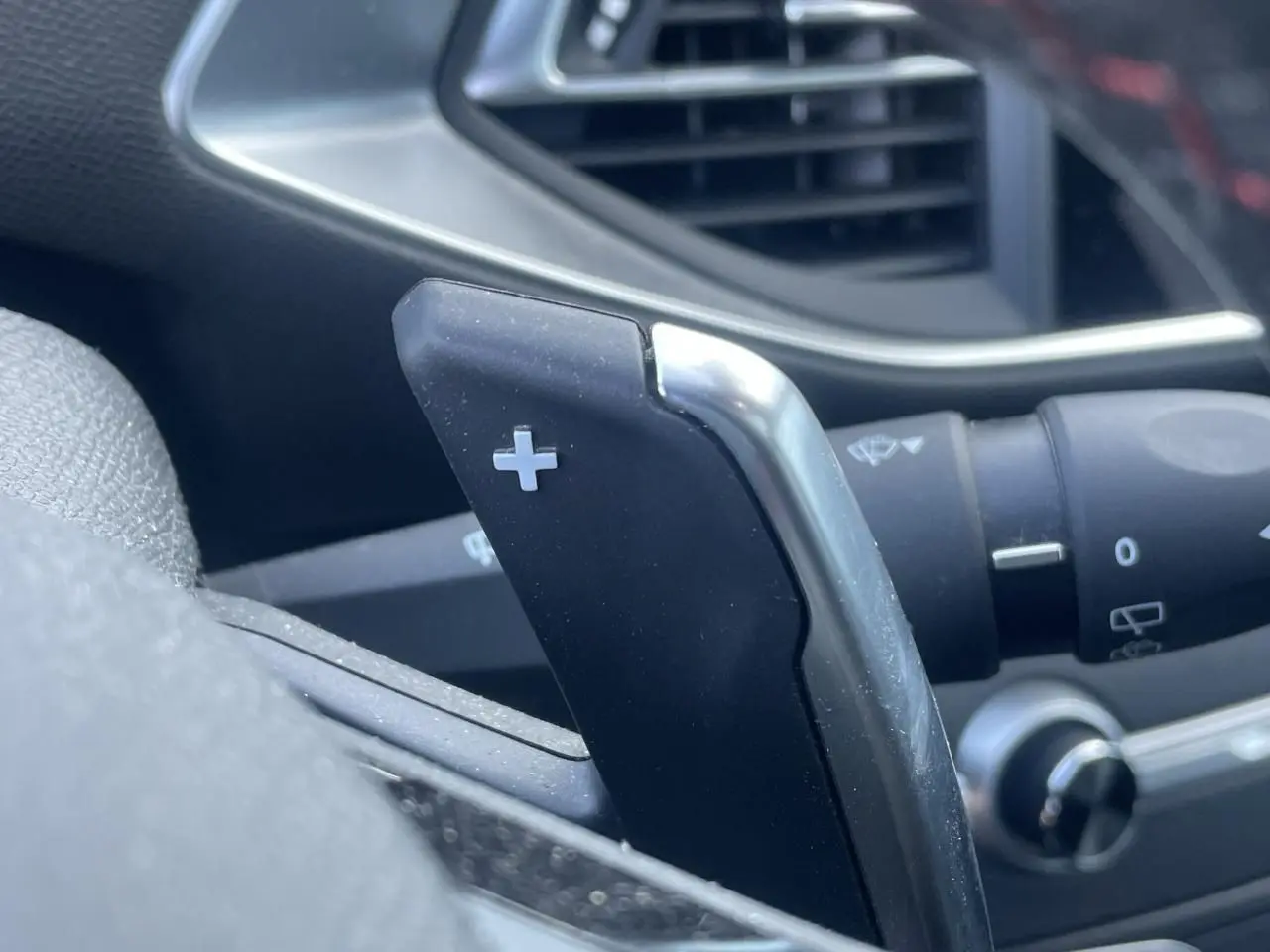 Gros plan sur la palette de changement de vitesse + côté droit du volant d'une Peugeot 308 SW bleu Vertigo.