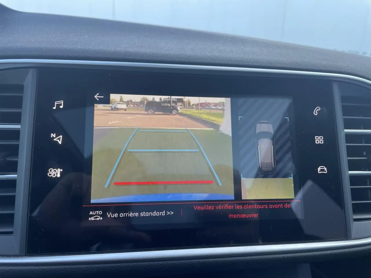 Écran tactile de la Peugeot 308 SW bleu Vertigo montrant la caméra de recul et l'aide au stationnement arrière.