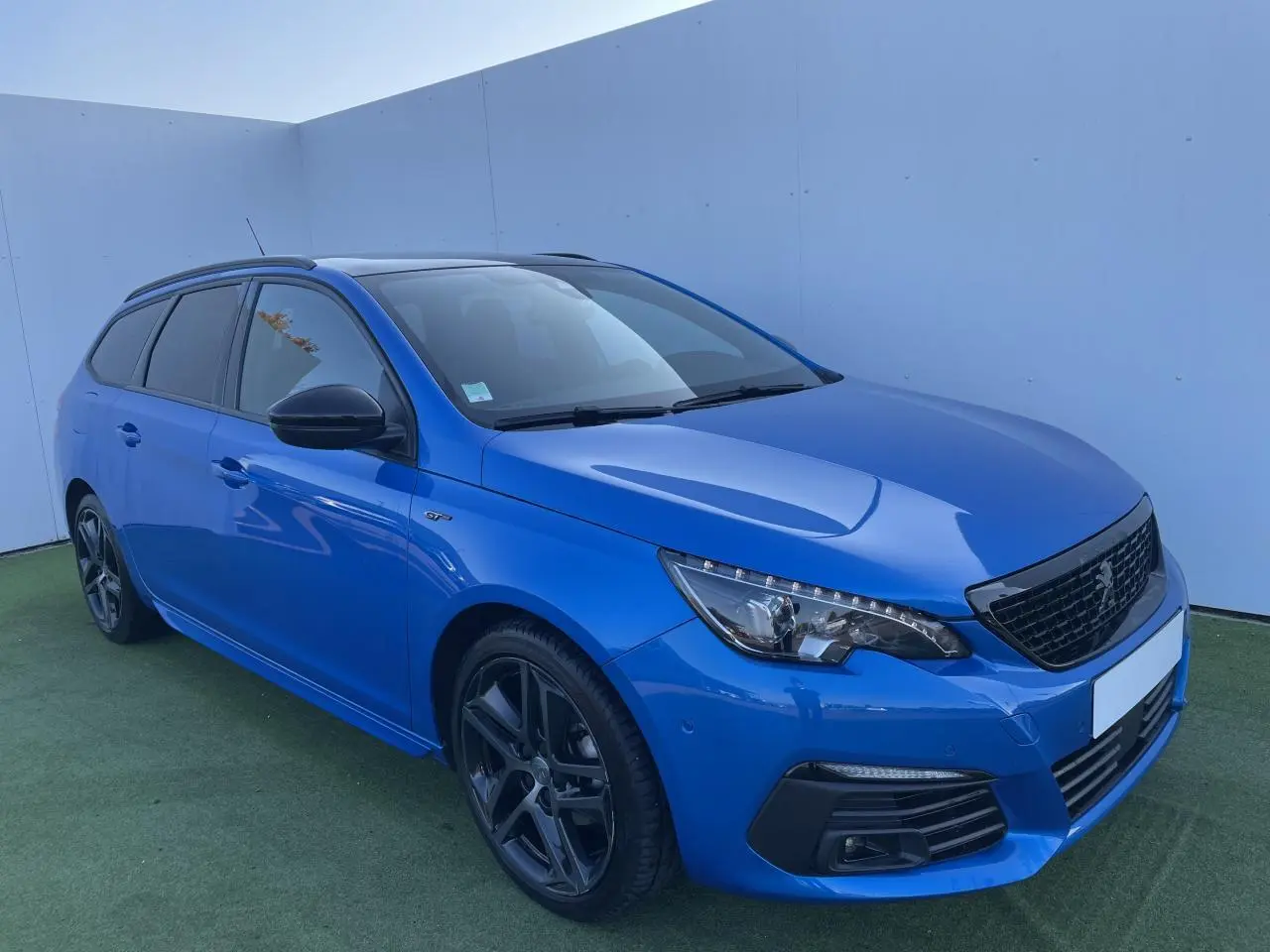 Peugeot 308 II SW bleu Vertigo vue 3/4 avant droit avec jantes noires et toit panoramique en verre