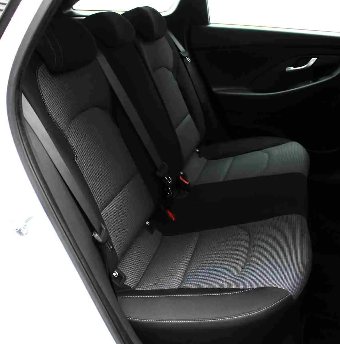 Vue latérale du siège arrière en tissu gris noir de la Hyundai i30 SW blanc polaire 2022, porte ouverte côté gauche.