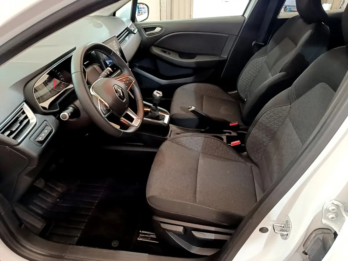Intérieur avant droit de la Renault Clio Business TCe 100 2020 blanche, volant cuir et sièges tissu gris foncé.