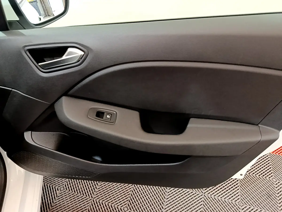 Gros plan sur la porte côté gauche intérieure de la Renault Clio Business blanche, avec commande de vitre électrique.