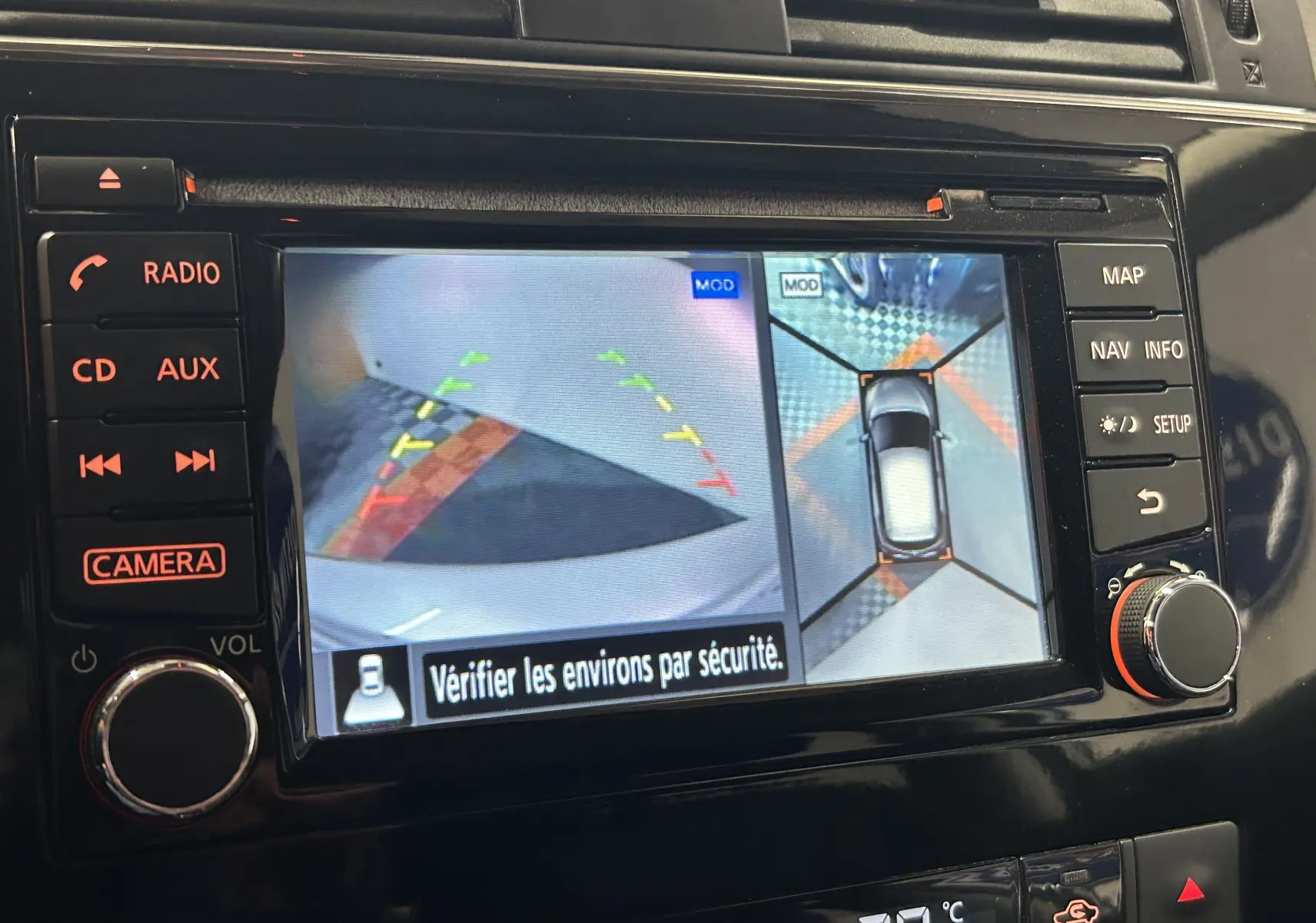 Écran central de la Nissan Pulsar 2018 montrant la caméra 360° avec vue arrière et vue aérienne du véhicule gris.