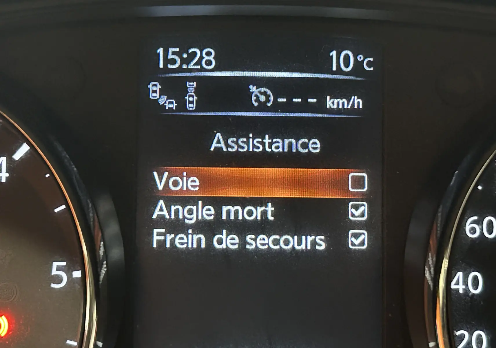 Affichage du tableau de bord de la Nissan Pulsar gris, montrant les options d'assistance avec angle mort et frein de secours activés.