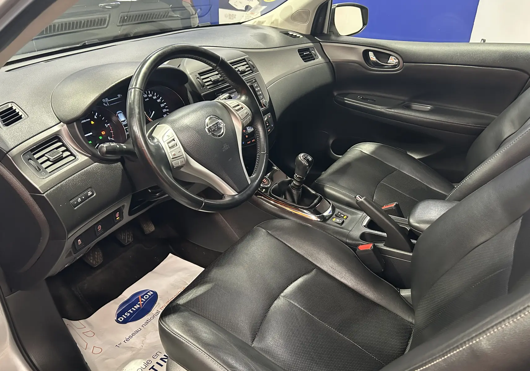 Vue intérieure côté conducteur du Nissan Pulsar 1.5 dCi 2018 avec sièges cuir noirs et boîte manuelle visible.